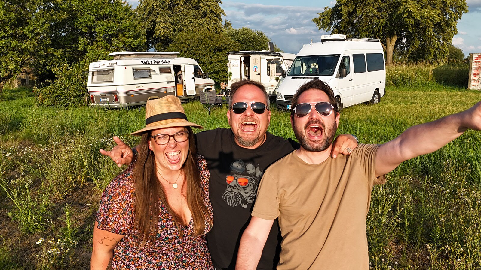 ABF 2026 News, Natural Born Campers Gruppenbild, zwei Männer und eine Frau mit Wohnmobilen im Sonner auf einer Wiese